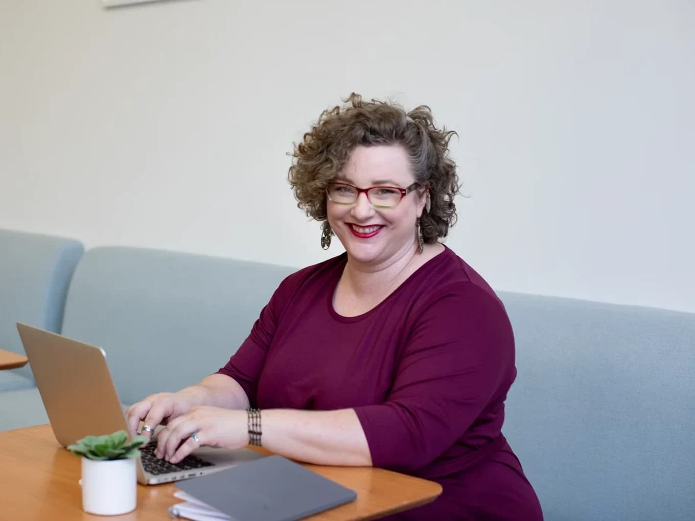 An office worker typing on a laptop at a table
